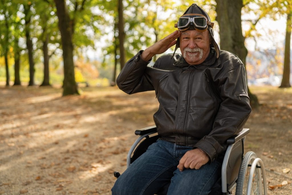 An aging veteran in a wheelchair offering a salute outdoors in Cape Coral, Florida, on Memorial Day