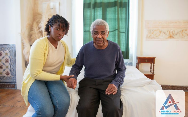 A Perfect Choice companion caregiver sitting supportively next to an elderly man in his Florida home