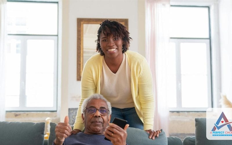 Smiling home caregiver supporting an older man with dementia in his Southwest Florida living room