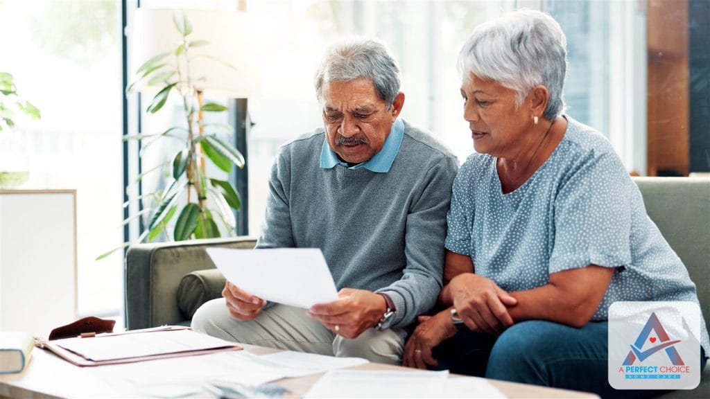 Senior couple reviewing a long-term care insurance document together on the couch at home