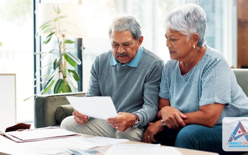 Senior couple reviewing a long-term care insurance document together on the couch at home
