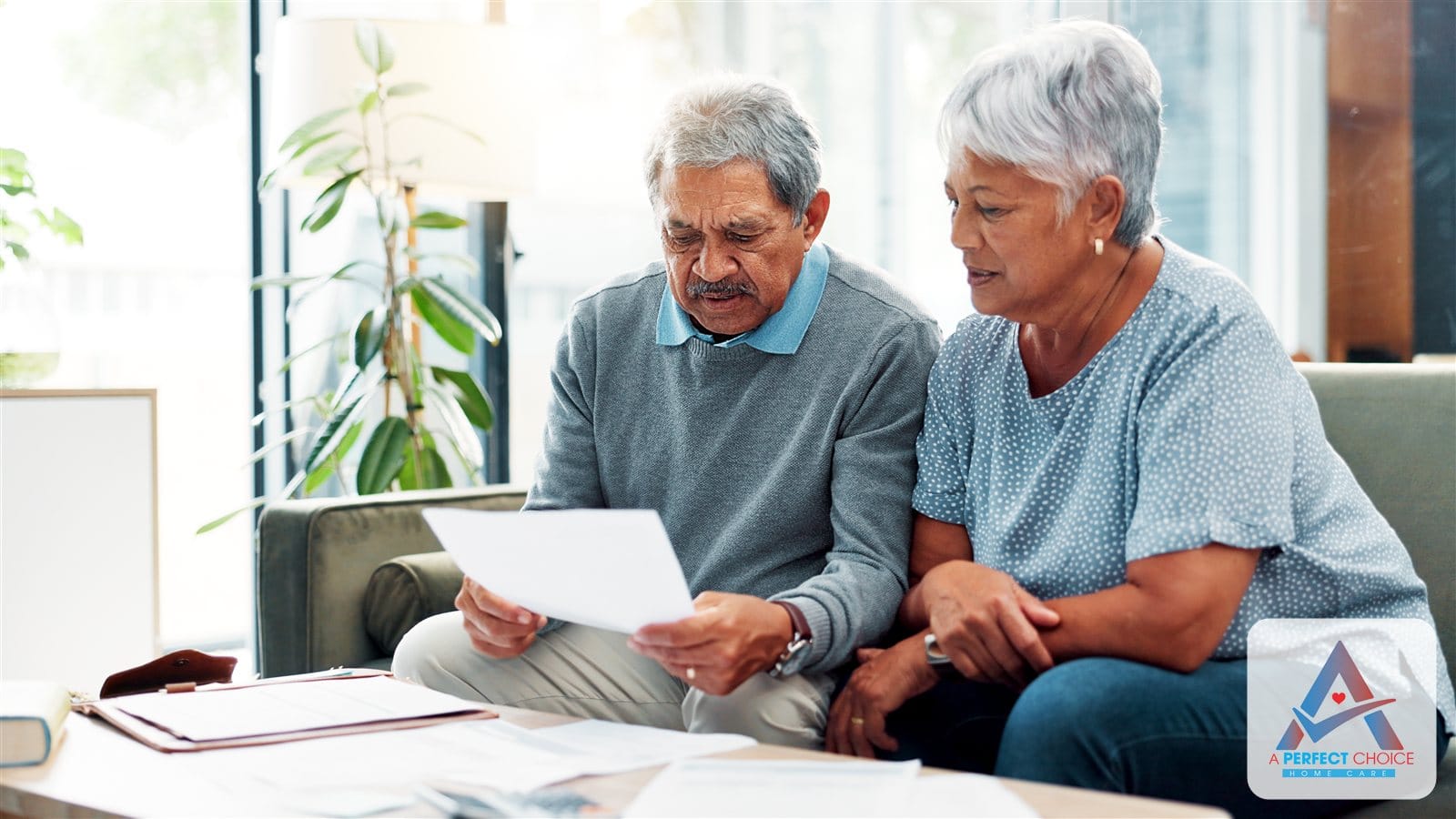 Senior couple reviewing a long-term care insurance document together on the couch at home