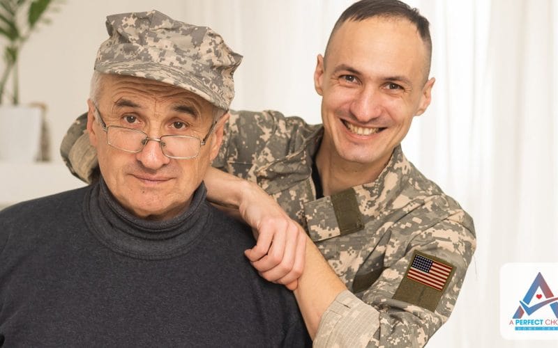 Senior veteran in a camouflage cap with his adult son smiling at home